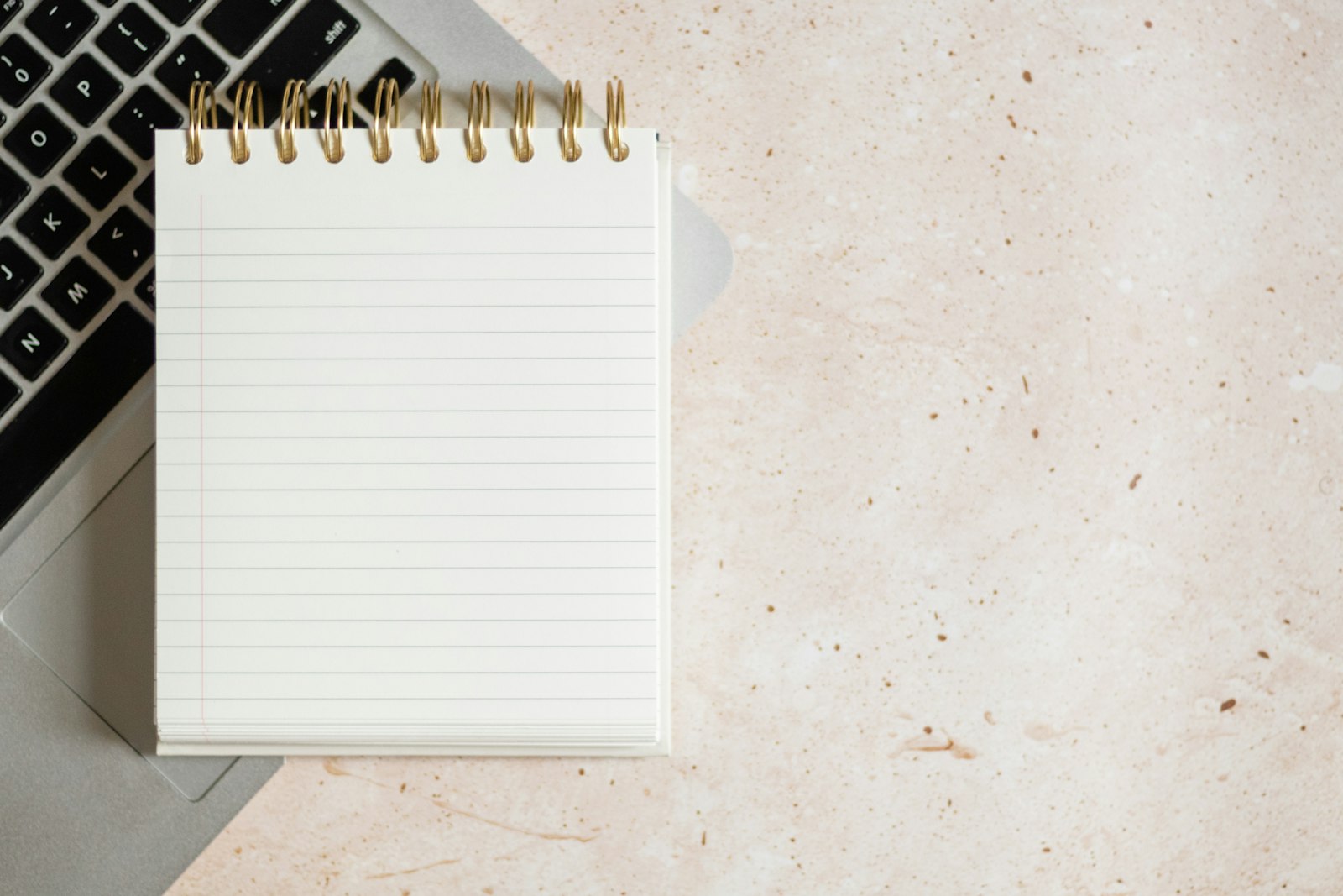 放在笔记本电脑上的记事本，作为编码前整理需求的主图。